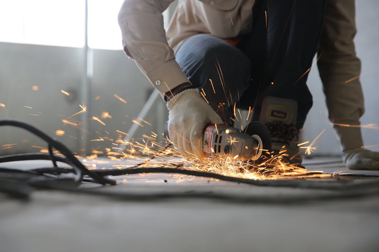hero-img A skilled industrial worker uses a grinder creating a burst of sparks indoors.