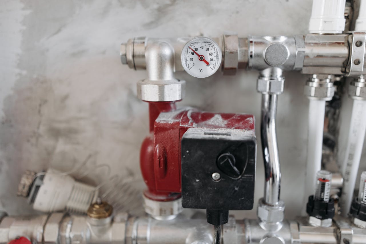 service-03 Close-up view of an industrial plumbing system featuring a pressure gauge and steel pipes.